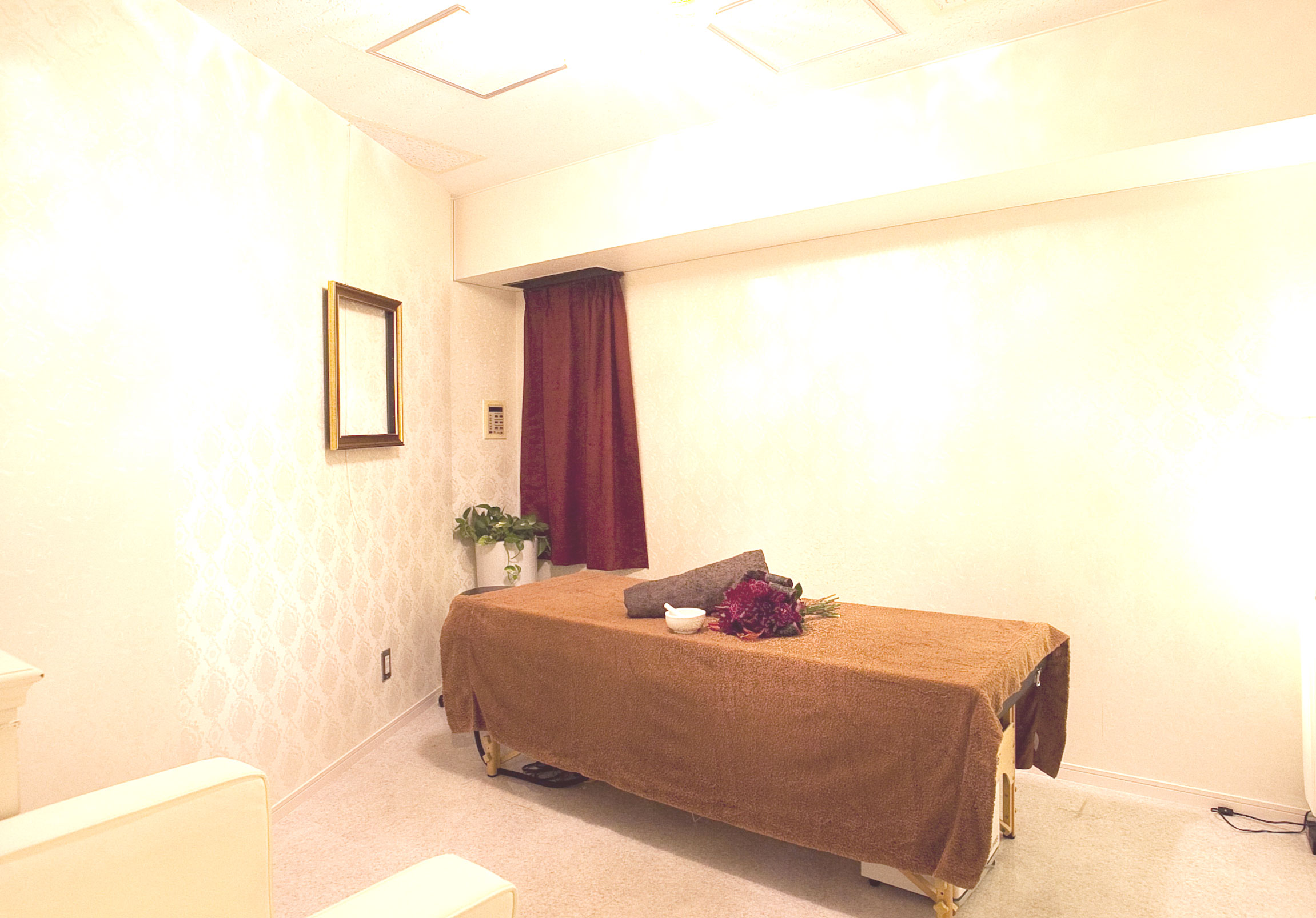 明るくおしゃれな部屋にエステ台が置かれている画像